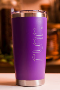 Purple tumbler with 'runr' engraving on a blurred background