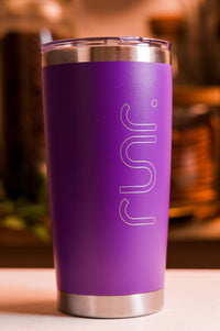 Purple tumbler with 'runr' engraving on a blurred background