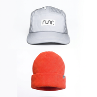 Lumos Silver running hat above coral reflective beanie